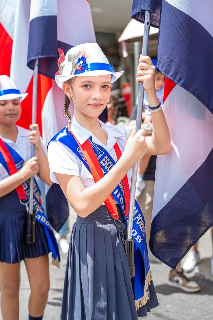 Little Girl in Shirt and Skirt Holding Flag at Parade in Costa Rica