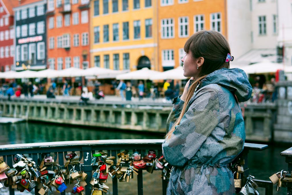 Woman Standing Near Orange, Yellow, and White Buildings