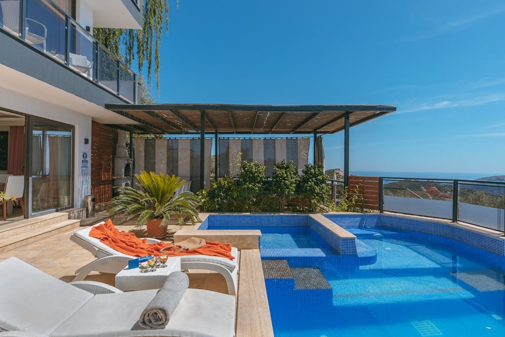 A large pool with lounge chairs and a view of the ocean